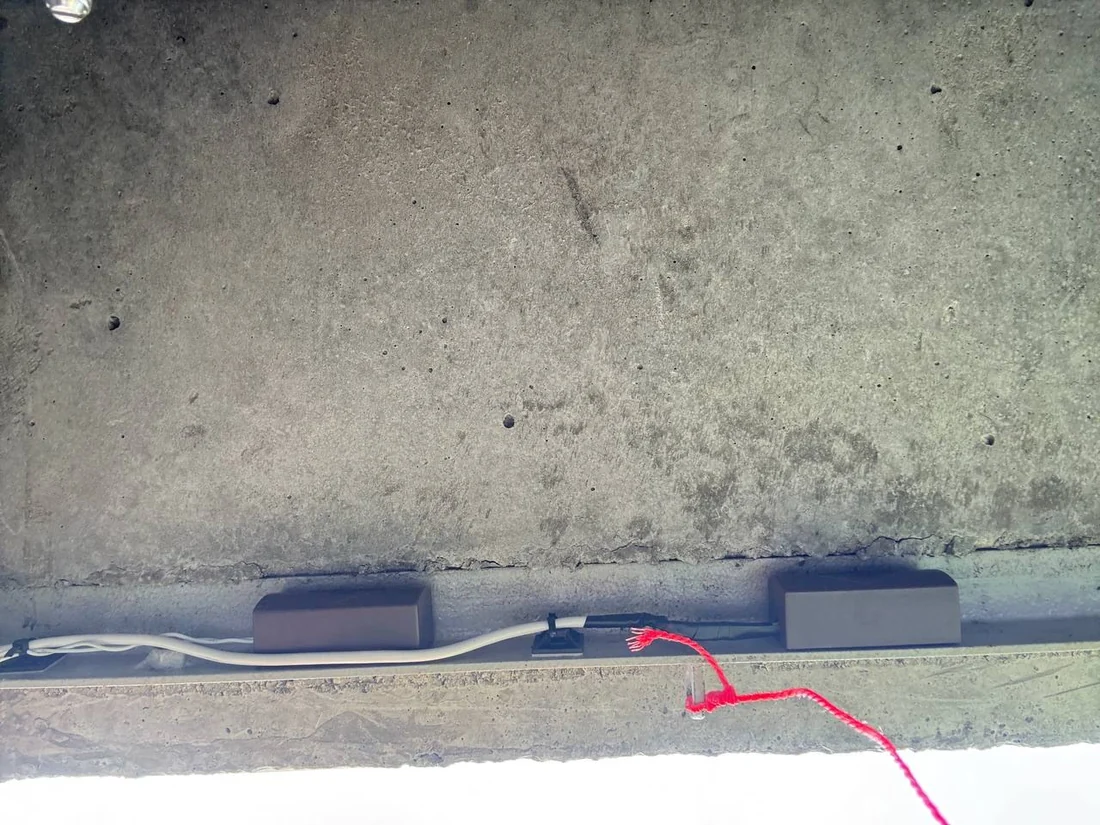 Sensor arrangement and connections on the underside of a concrete enclosure lid